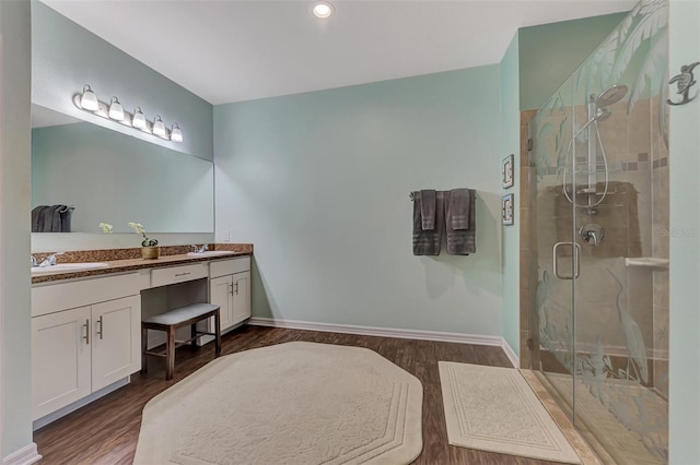 bathroom featuring walk in shower, hardwood / wood-style flooring, and double sink vanity