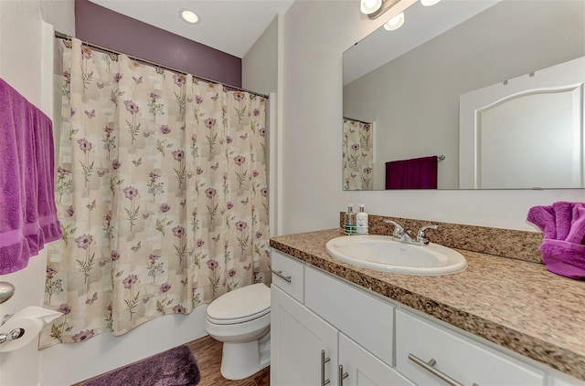 full bathroom with hardwood / wood-style floors, vanity, toilet, and shower / bathtub combination with curtain