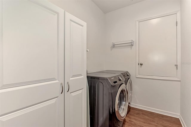 washroom featuring hardwood / wood-style floors and washing machine and clothes dryer