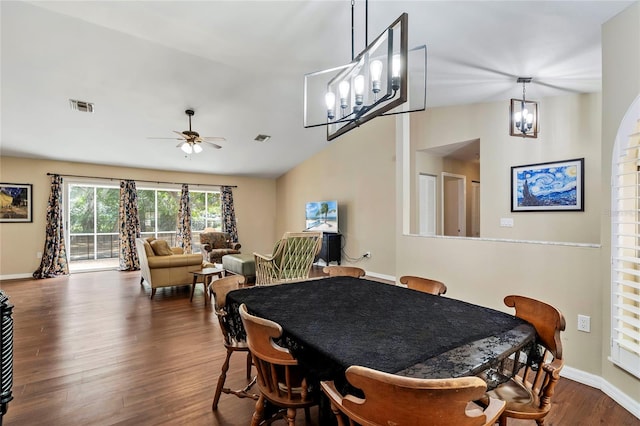 dining room with vaulted ceiling, ceiling fan with notable chandelier, and hardwood / wood-style flooring