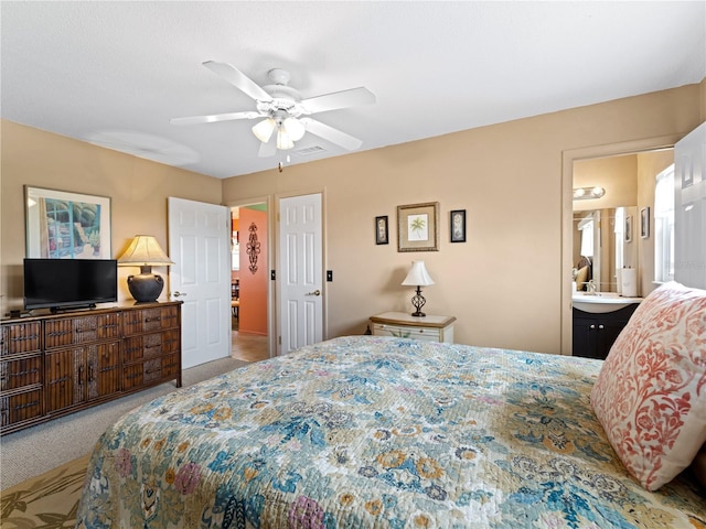 bedroom with connected bathroom, carpet flooring, and ceiling fan