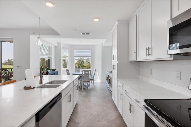 kitchen with light tile flooring, stainless steel appliances, white cabinetry, sink, and pendant lighting