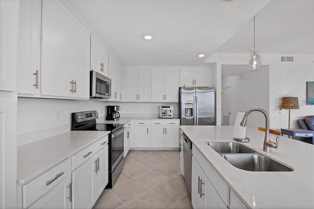 kitchen with stainless steel appliances, sink, light tile flooring, and white cabinets