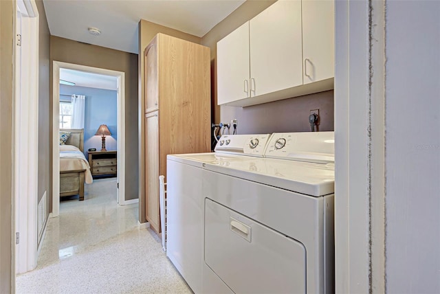 laundry area featuring cabinets and washing machine and dryer