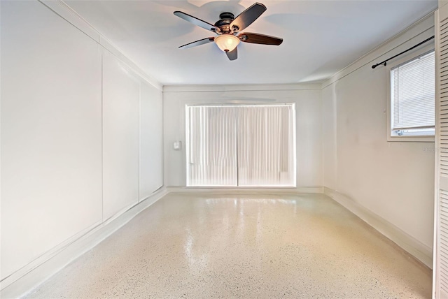 empty room featuring ceiling fan and crown molding