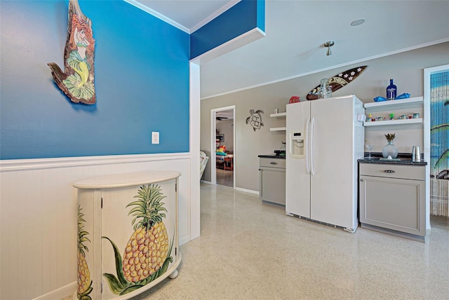 kitchen featuring gray cabinetry, white refrigerator with ice dispenser, and crown molding