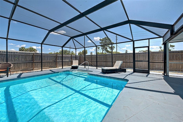 view of pool featuring glass enclosure and a patio area