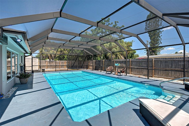 view of swimming pool with glass enclosure, a patio, and a storage shed