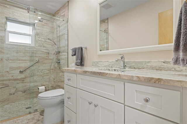 bathroom with a shower with shower door, toilet, and vanity