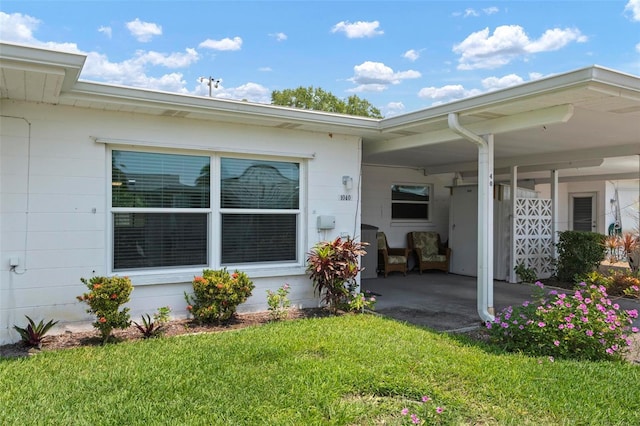 entrance to property featuring a lawn