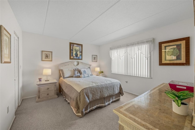 bedroom with light carpet and a textured ceiling