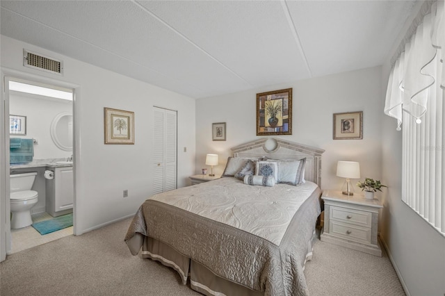 carpeted bedroom featuring ensuite bathroom, sink, and a closet