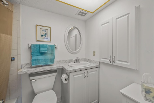 bathroom featuring vanity, toilet, and walk in shower