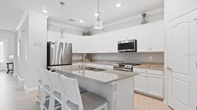 kitchen with decorative light fixtures, light tile flooring, an island with sink, appliances with stainless steel finishes, and sink