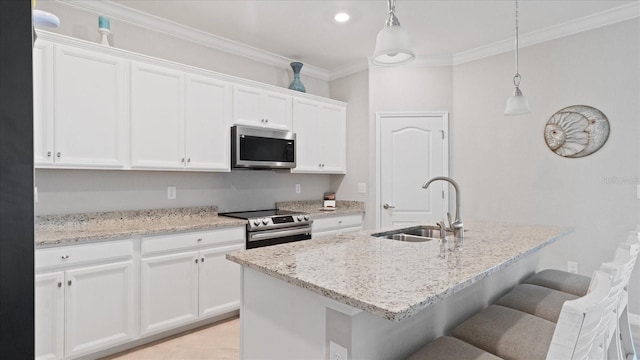 kitchen featuring hanging light fixtures, a center island with sink, appliances with stainless steel finishes, and white cabinetry