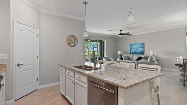 kitchen with a center island with sink, stainless steel dishwasher, white cabinets, pendant lighting, and sink