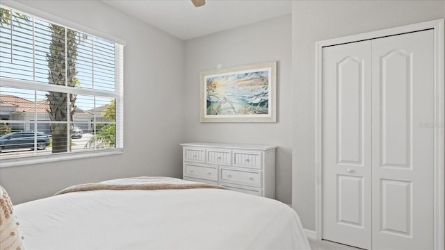 carpeted bedroom featuring ceiling fan and a closet