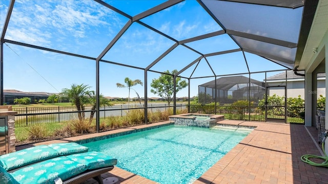 view of pool featuring glass enclosure, an in ground hot tub, and a patio area