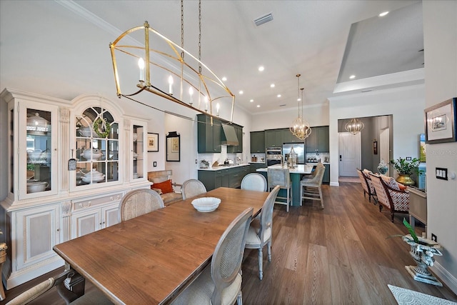 dining area featuring dark hardwood / wood-style flooring, a notable chandelier, and ornamental molding