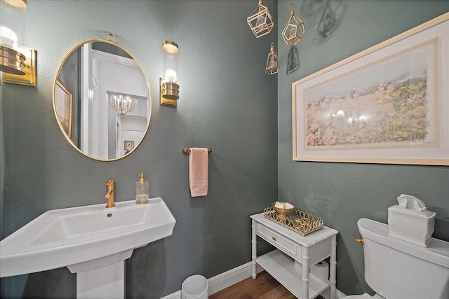 bathroom with toilet, sink, and hardwood / wood-style floors