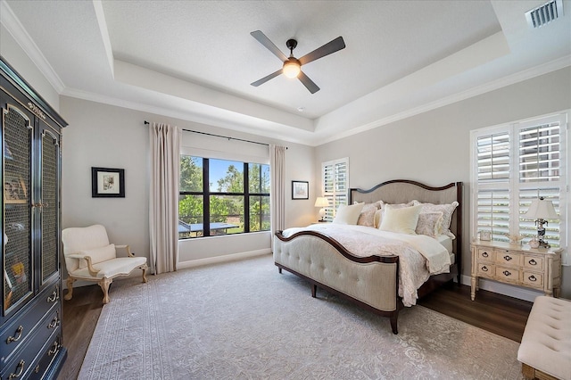 bedroom featuring ornamental molding, ceiling fan, and a tray ceiling