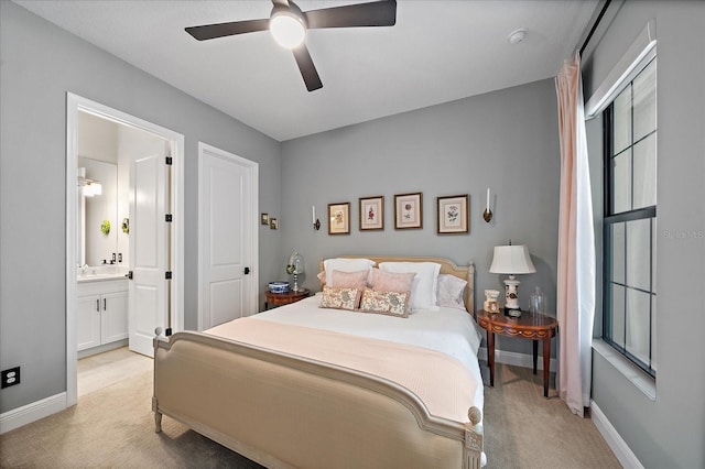 bedroom with light carpet, connected bathroom, and ceiling fan