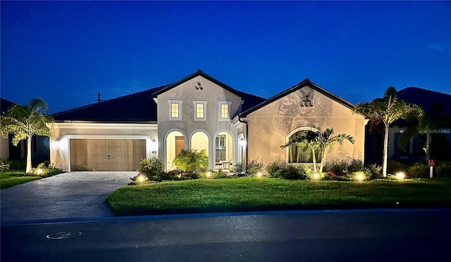 view of front of property featuring a garage and a lawn