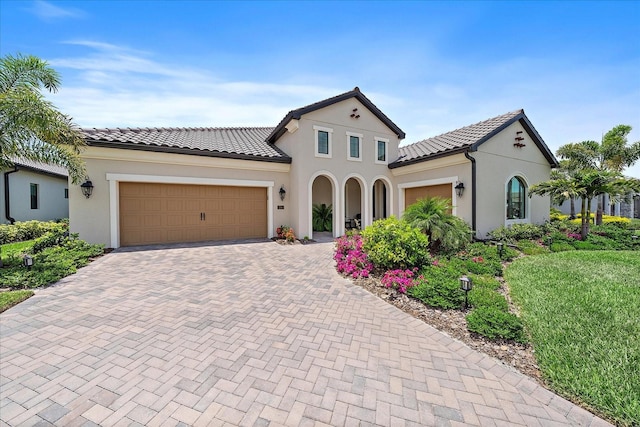 284 Bocelli Dr, Nokomis, FL 34275 - mediterranean / spanish home featuring an attached garage, decorative driveway, stucco siding, and a tile roof