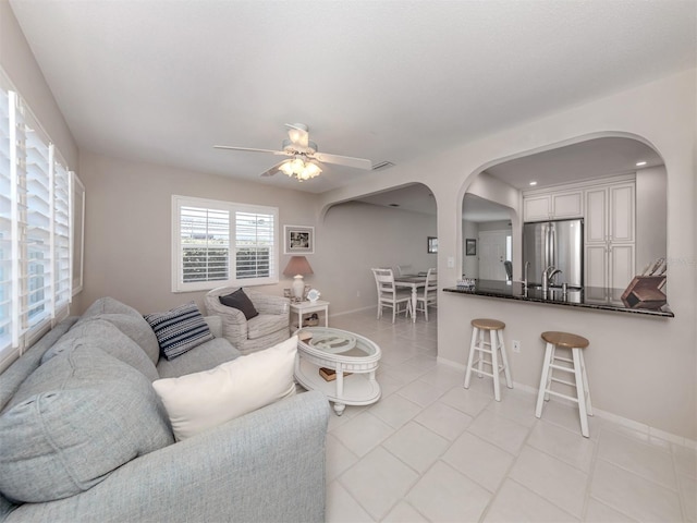 living room with ceiling fan and light tile patterned flooring