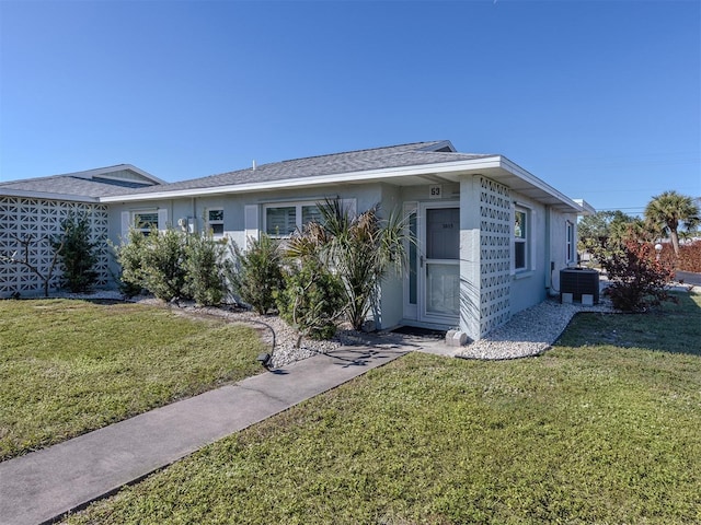 single story home featuring central air condition unit and a front lawn