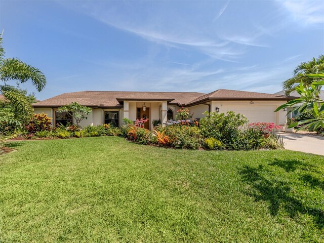 single story home featuring a garage and a front lawn