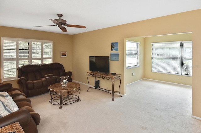 living room with light colored carpet, ceiling fan, and a healthy amount of sunlight