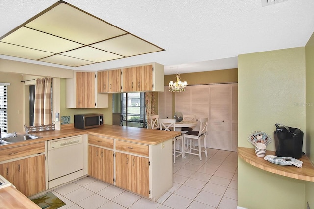 kitchen featuring kitchen peninsula, white dishwasher, sink, an inviting chandelier, and hanging light fixtures