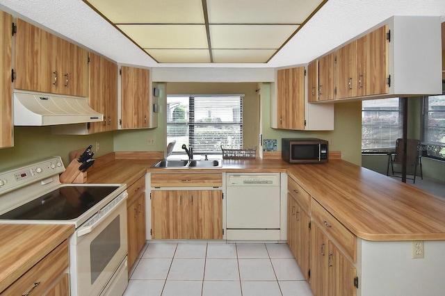 kitchen featuring sink, white appliances, and light tile patterned flooring