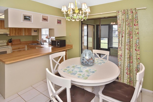 tiled dining area with sink and a chandelier