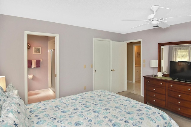 tiled bedroom with ceiling fan, a textured ceiling, and ensuite bath