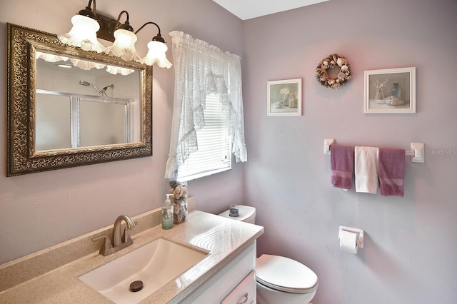 bathroom with vanity, an enclosed shower, and toilet