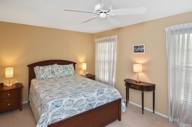 carpeted bedroom featuring ceiling fan and multiple windows