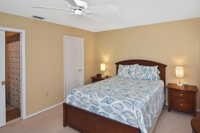 bedroom featuring ensuite bath, ceiling fan, and light colored carpet