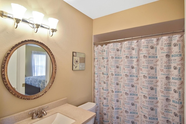 bathroom featuring vanity, toilet, and walk in shower