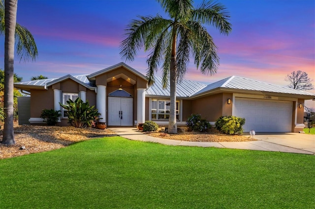 ranch-style house featuring a garage and a yard