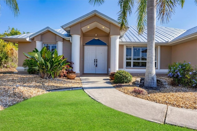 view of exterior entry featuring a lawn