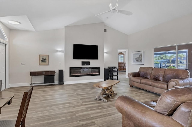 living room with ceiling fan, high vaulted ceiling, and light wood-type flooring