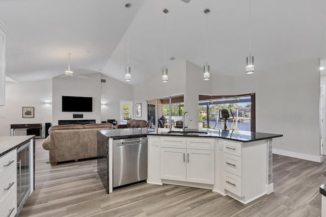 kitchen featuring decorative light fixtures, white cabinetry, an island with sink, light wood-type flooring, and stainless steel dishwasher