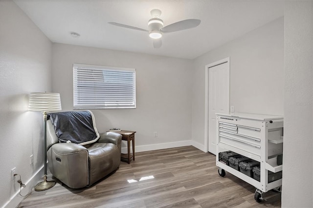 sitting room with light wood-type flooring and ceiling fan