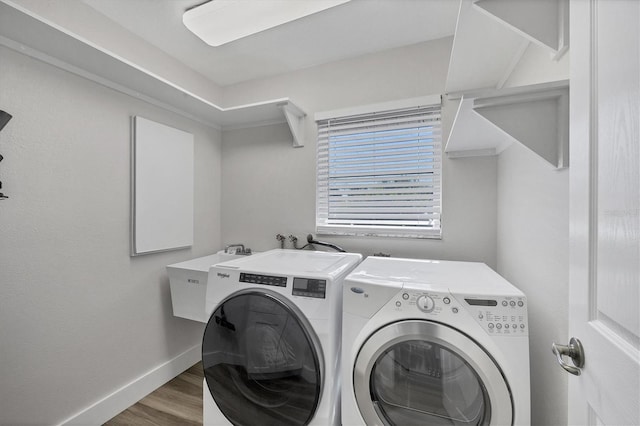 washroom with washer and dryer, sink, and hardwood / wood-style flooring