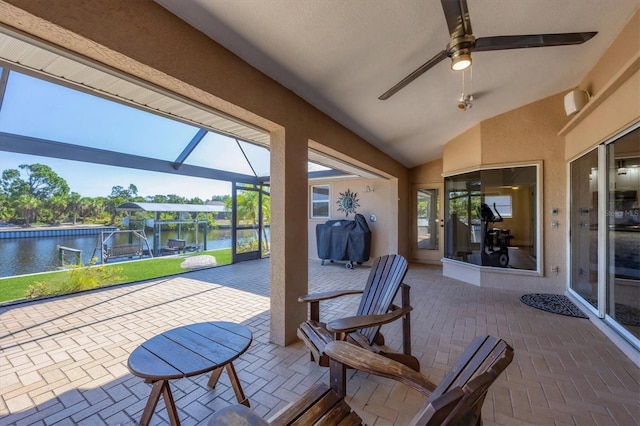 view of patio featuring area for grilling, a lanai, a water view, and ceiling fan