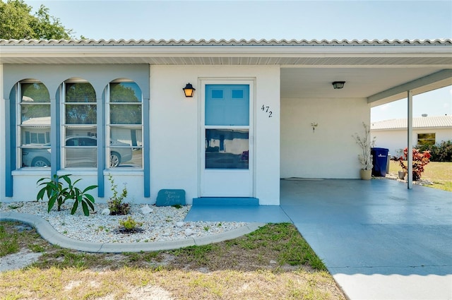 doorway to property featuring a carport