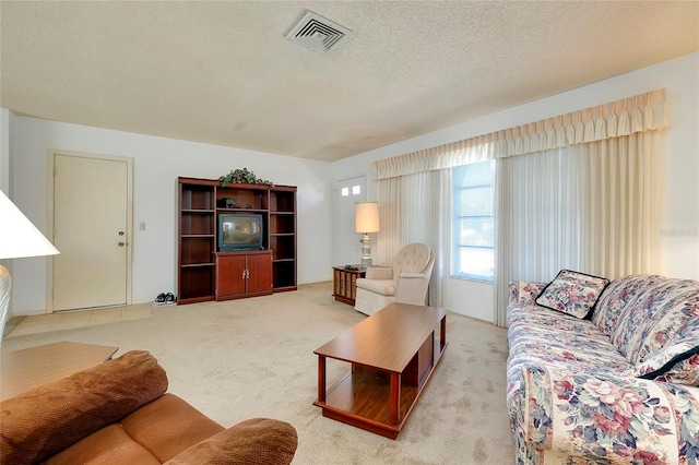 carpeted living room featuring a textured ceiling