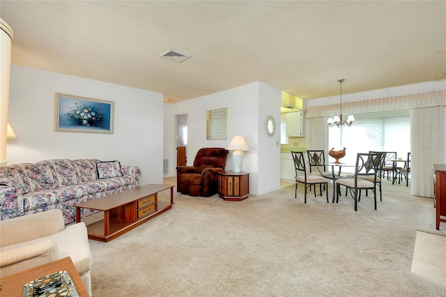 carpeted living room with a notable chandelier and a textured ceiling